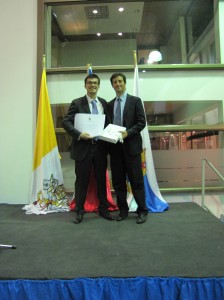 Andrés Maríhuen recibe el reconocmiendo a la Mejor Tesis 2014. Entrega el premio su profesor guía Matías Hube.