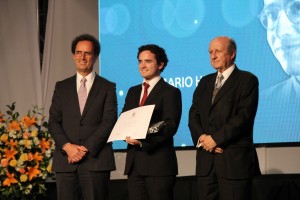 El director de la Fundación Mario Hiriart, profesor Juan Enrique Coeymans, y el decano Juan Carlos de la Llera entregando la distinción al alumno Diego Zavala.